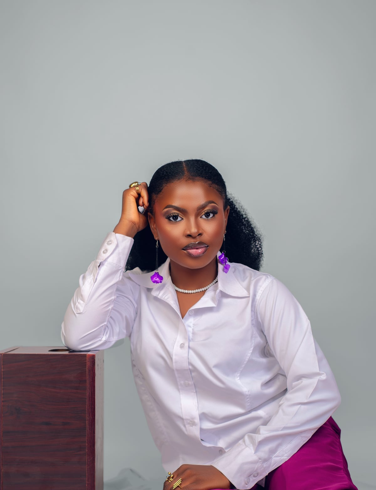 Ify Patience, founder of Glowsbeauty, in a white shirt and purple trousers